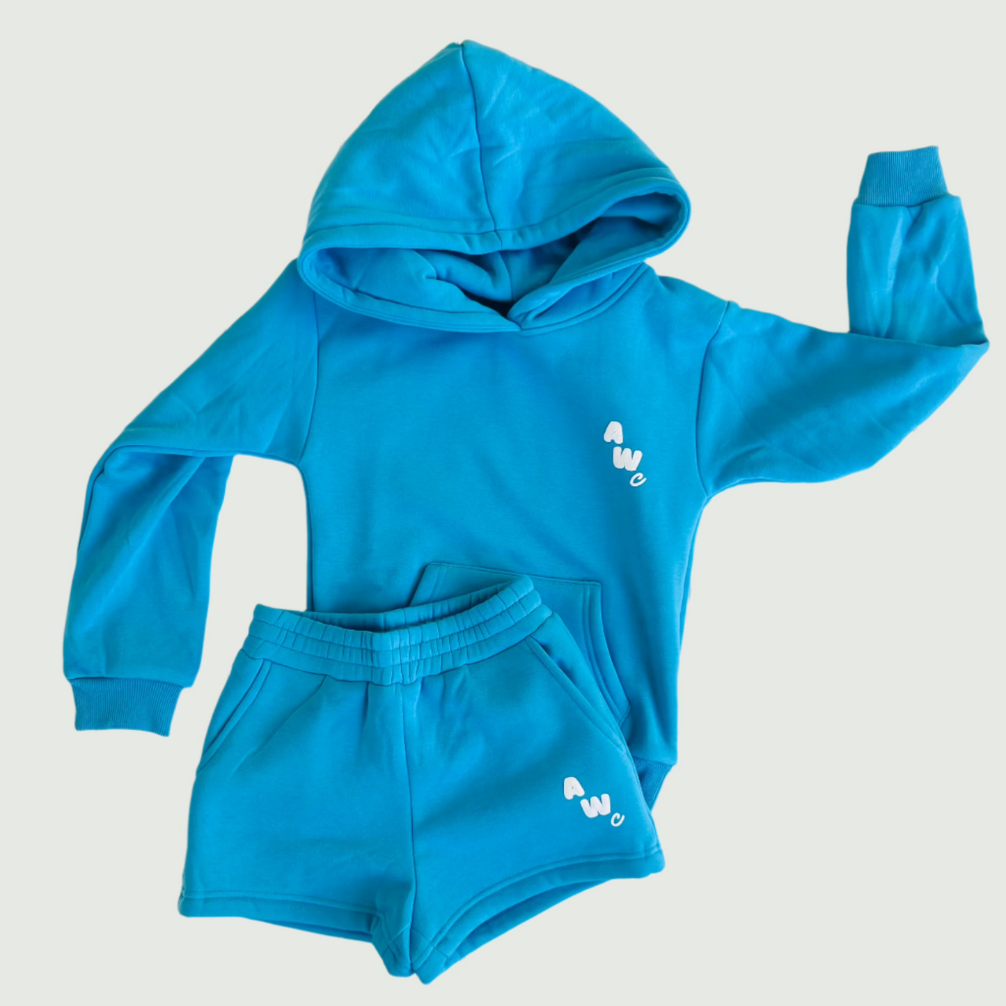Blue children's hoodie and shorts set on a white floor