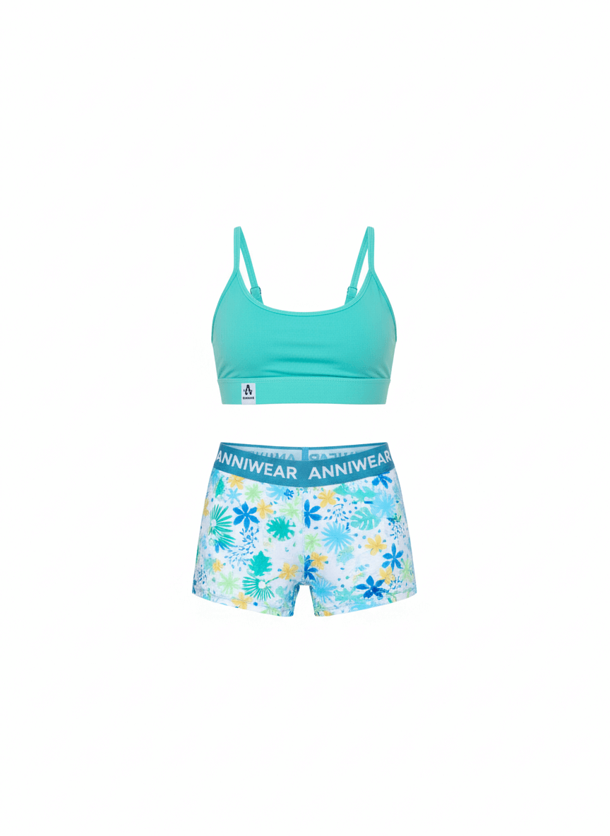 Turquoise sports bra and floral shorts set on a white background