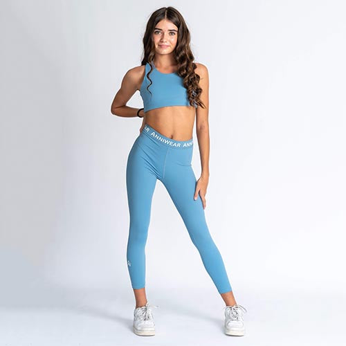 Blue sports bra and leggings with brand logo on a white background