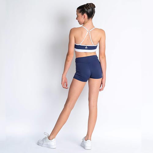 Navy blue & white sports crop and navy blue high-waisted shorts on a plain background