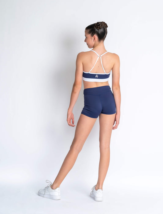 Navy blue & white sports crop and navy blue high-waisted shorts on a plain background