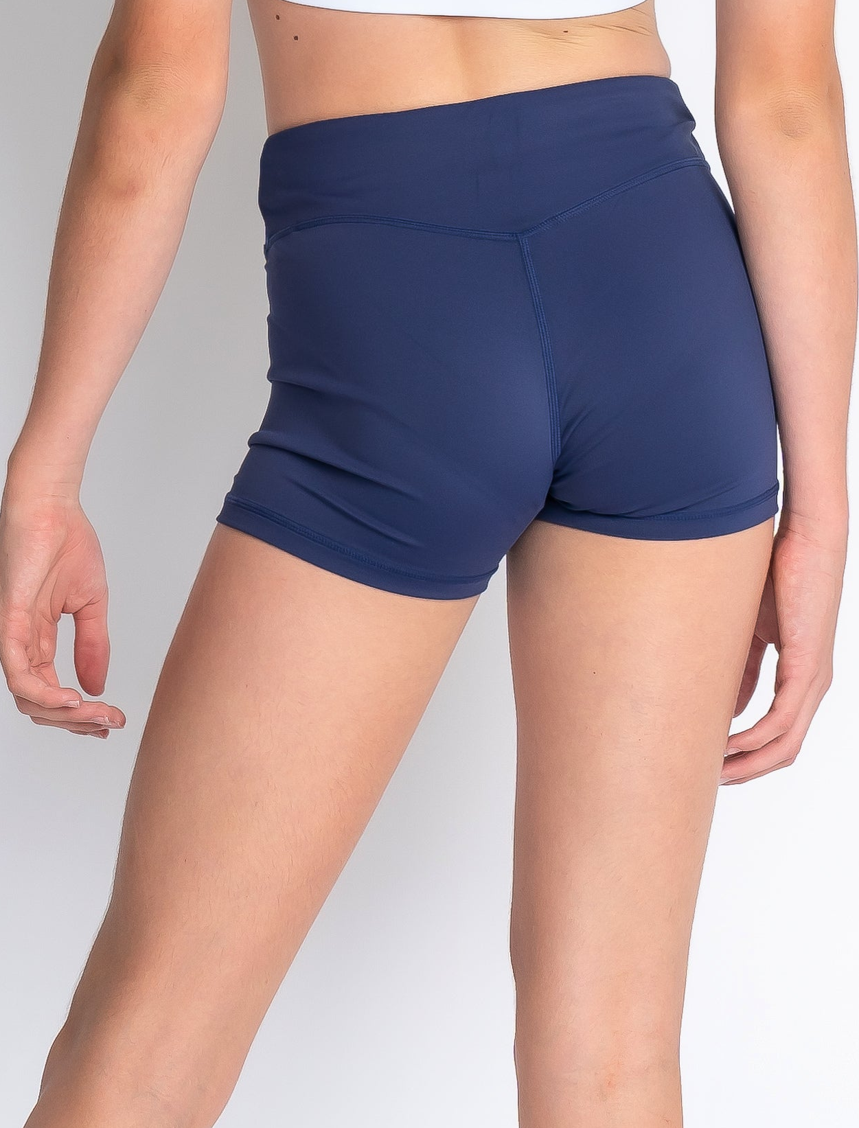 Navy blue athletic shorts worn by a person on a plain background