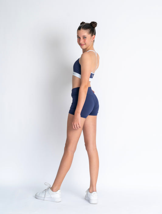 Navy blue sports bra with white accents and 'Anniwear' branding on a plain background