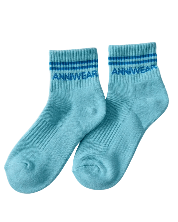 Pair of light blue socks with blue stripes and 'ANNIWEAR' branding on a white background