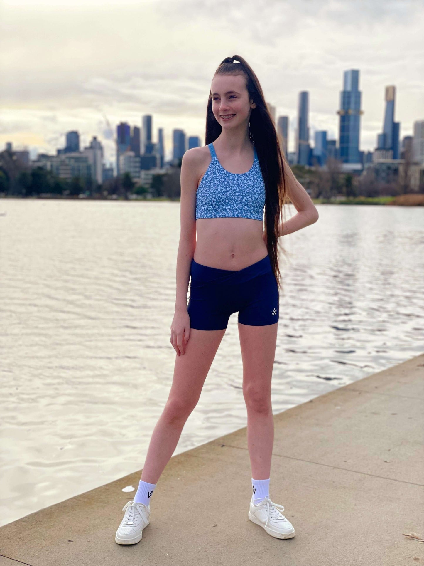 Blue floral sports bra and navy high waisted shorts on a person