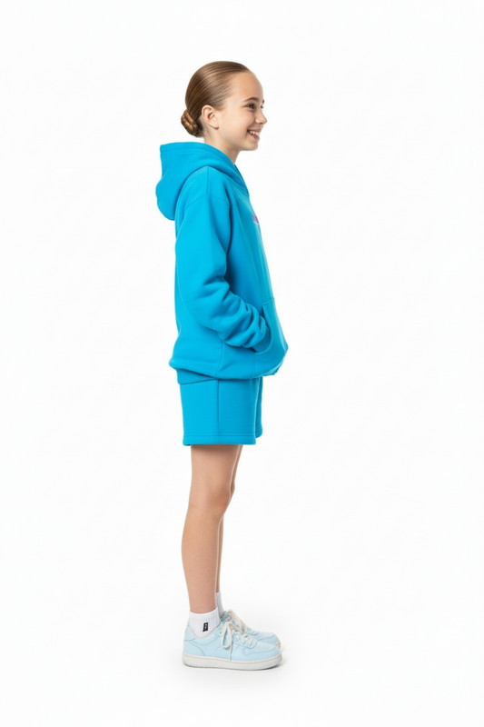 Child wearing a blue hoodie and shorts on a white background
