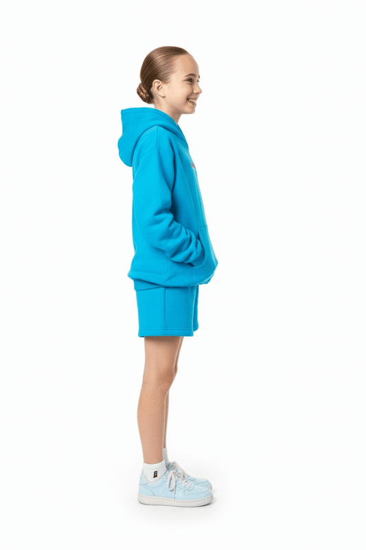 Child wearing a blue hoodie and shorts on a white background