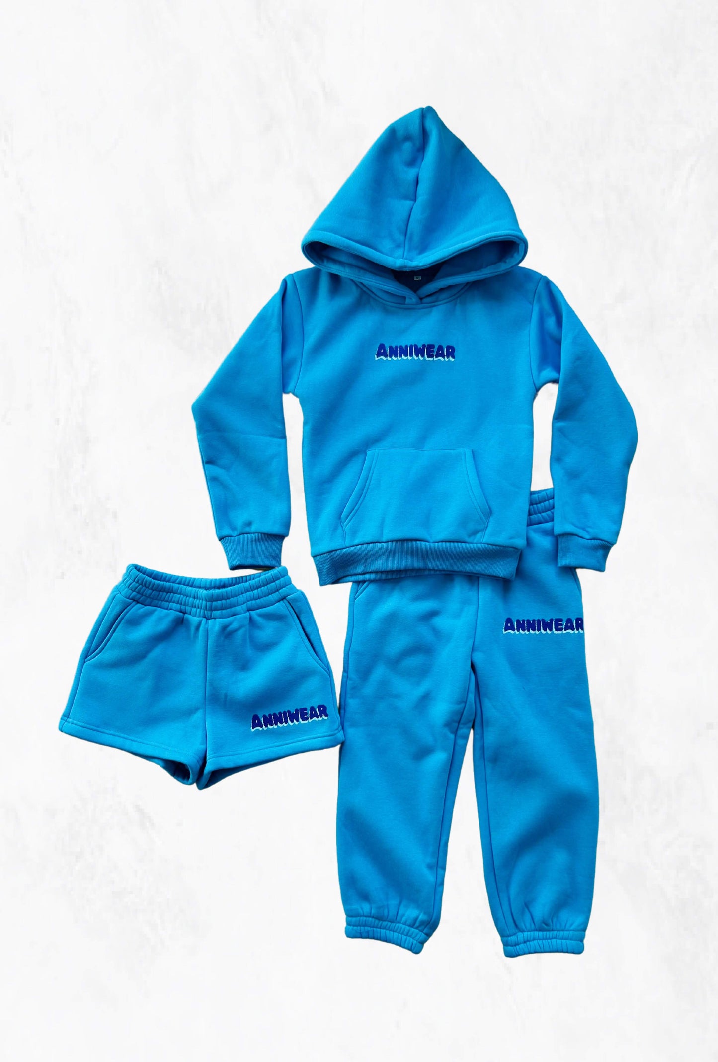 Blue tracksuit and shorts with 'ANNIWEAR' branding on white background
