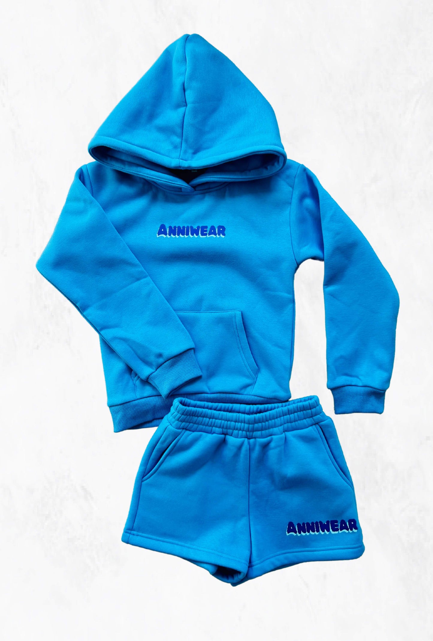 A blue two-piece loungewear set consisting of a hoodie and matching shorts, with the brand name 'Anniwear' visible on the hoodie.