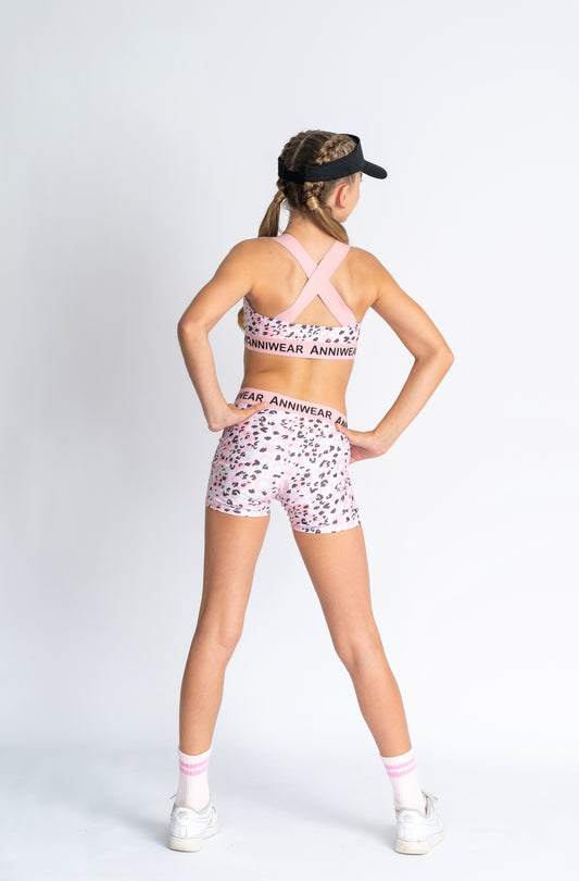 Pink animal print patterned active crop and shorts with 'Anniwear' branding on a white background