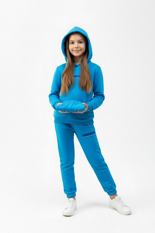 Person wearing a blue tracksuit with a hood holding a pair of sweat shorts on a white background