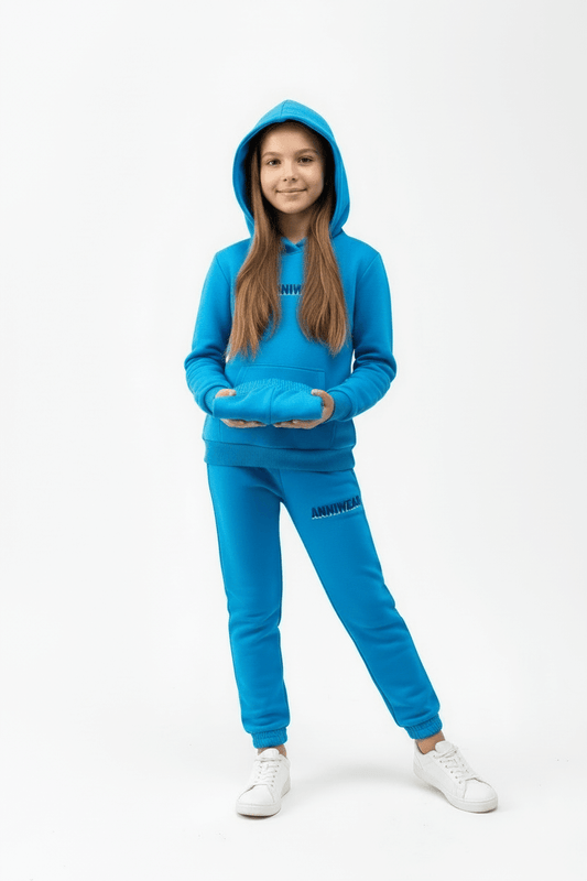 Person wearing a blue tracksuit with a hood holding a pair of sweat shorts on a white background