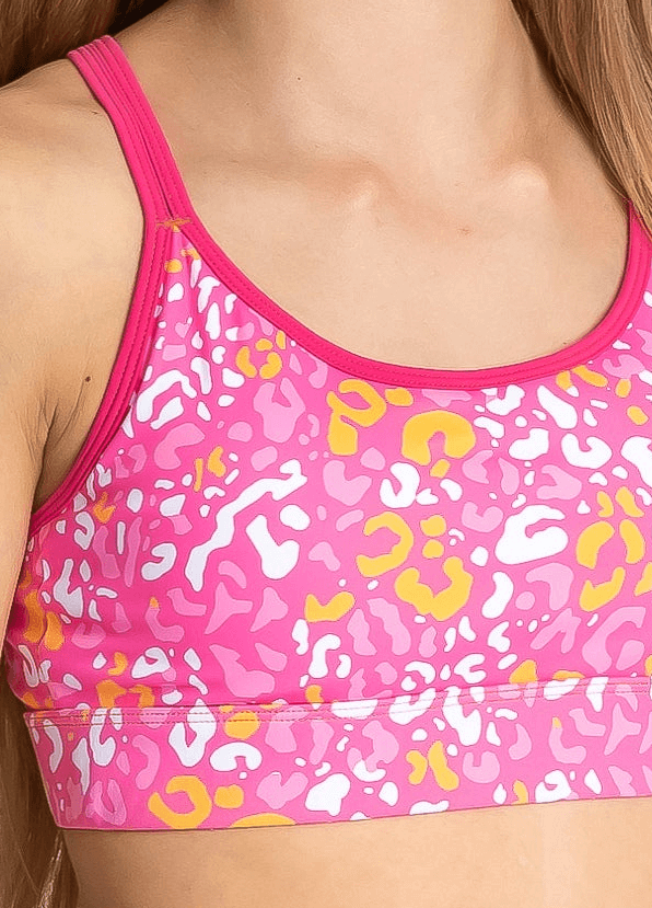 Pink sports bra with colorful animal print pattern on a white background