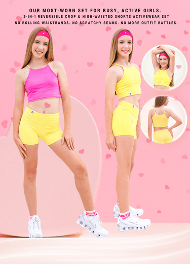 Two women wearing a pink and yellow reversible crop top and high-waisted shorts activewear set on a pink background with heart shapes.