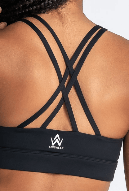 Black sports bra with criss-cross straps and a visible brand logo on a neutral background