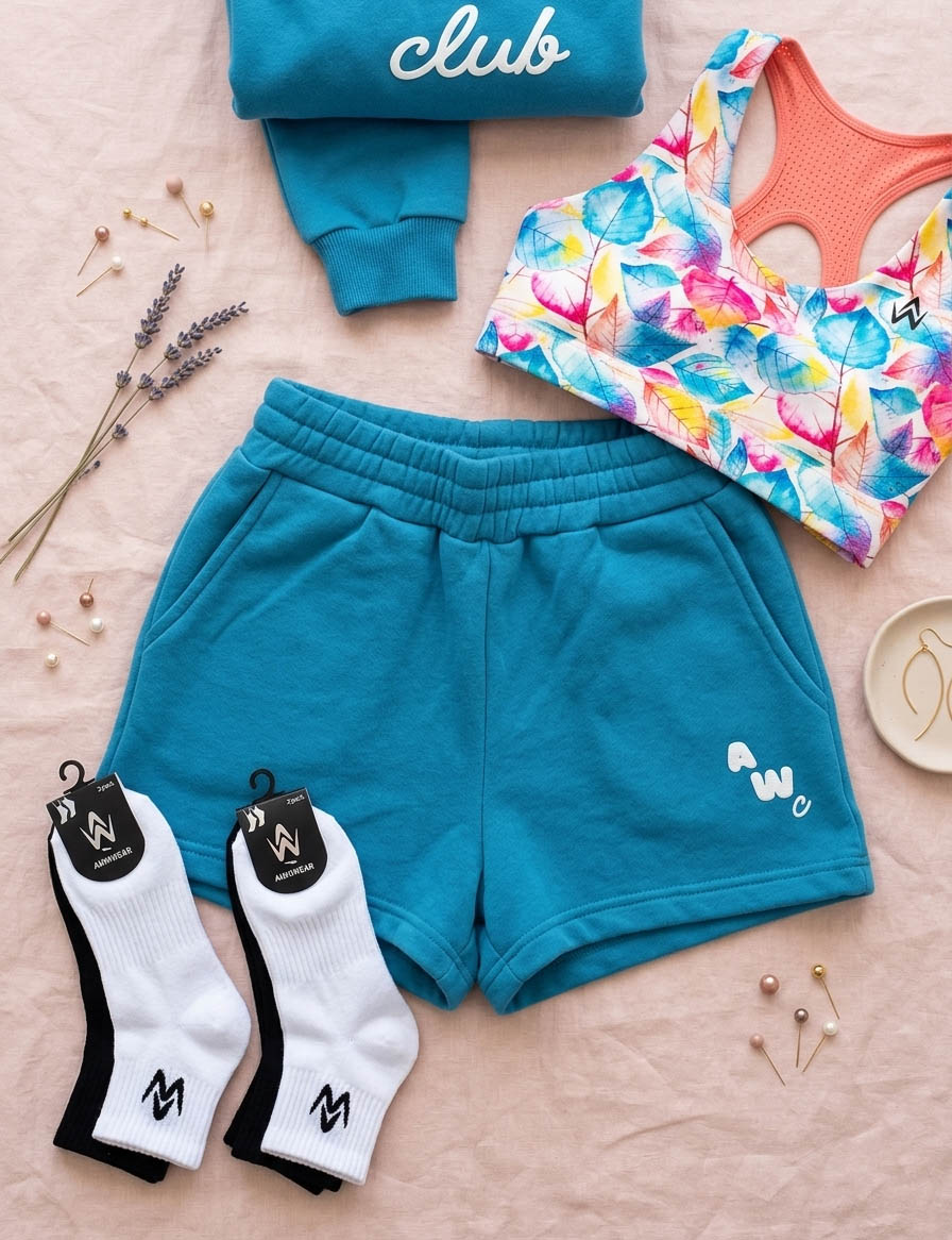 flat lay of sports crop top, shorts, socks on a pink minimalist background