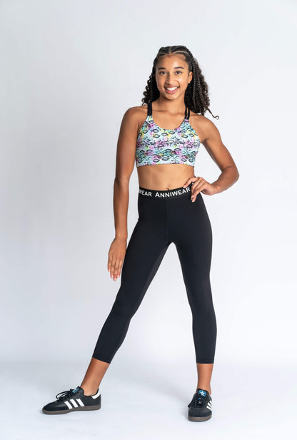 Girl wearing neon animal print crop & black activewear Tights