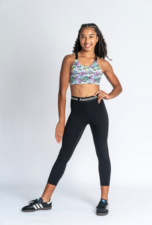Girl wearing neon animal print crop & black activewear Tights