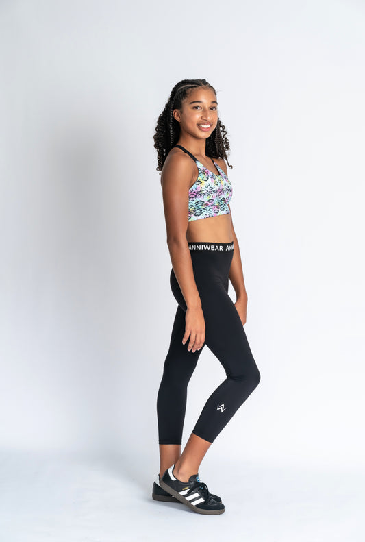 Girl wearing neon animal print crop & black activewear Tights