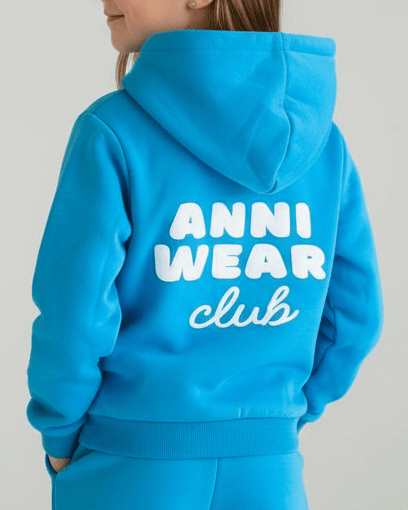 Person wearing a blue hoodie with 'ANNI WEAR club' text on the back against a gray background