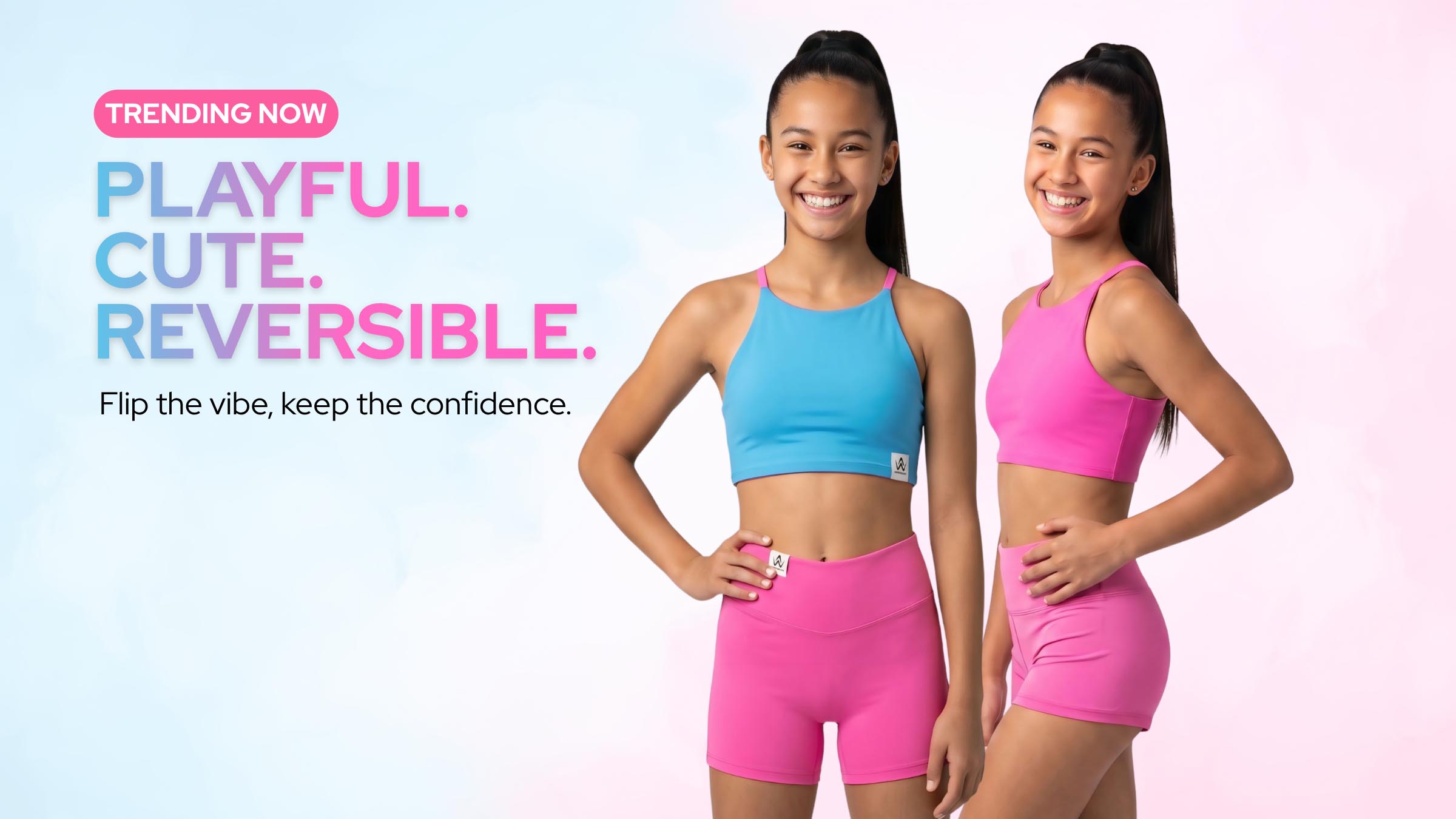 Two young girls modeling matching athletic wear, one in a blue sports bra and pink shorts, and the other in a pink sports bra and pink shorts, standing against a pastel pink and blue gradient background with promotional text on the left.