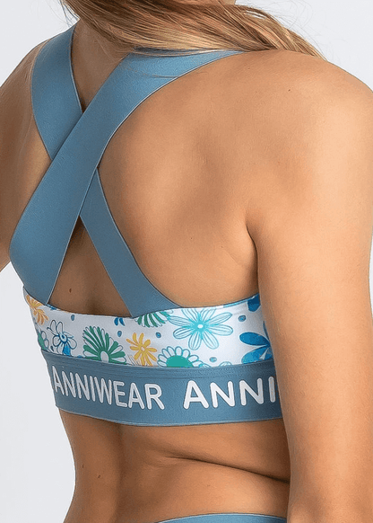 Blue sports bra with floral design and 'ANNIWEAR' branding on a white background