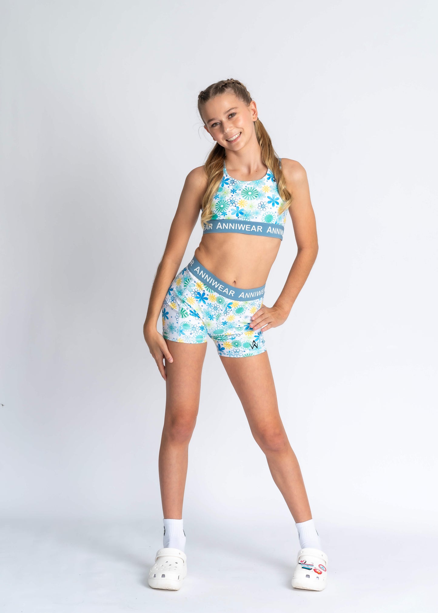 Girl wearing Floral-patterned activewear with 'ANNIWEAR' waistband on a white background