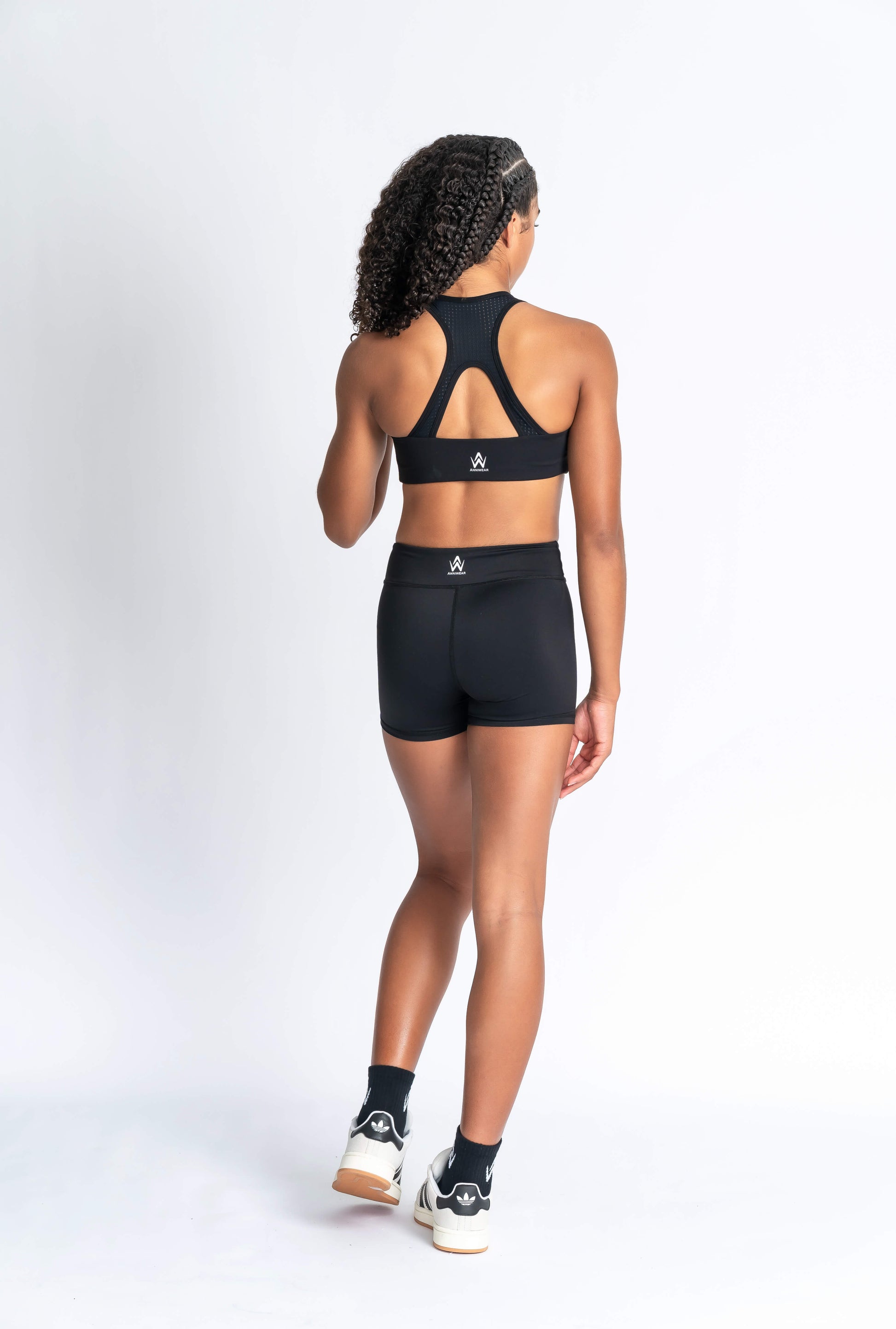 Black sports bra and black shorts with white logo branding