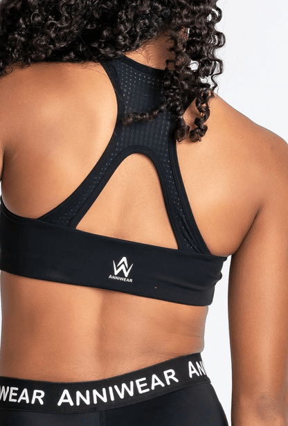 Black sports bra and leggings with 'Anniwear' branding on a plain background
