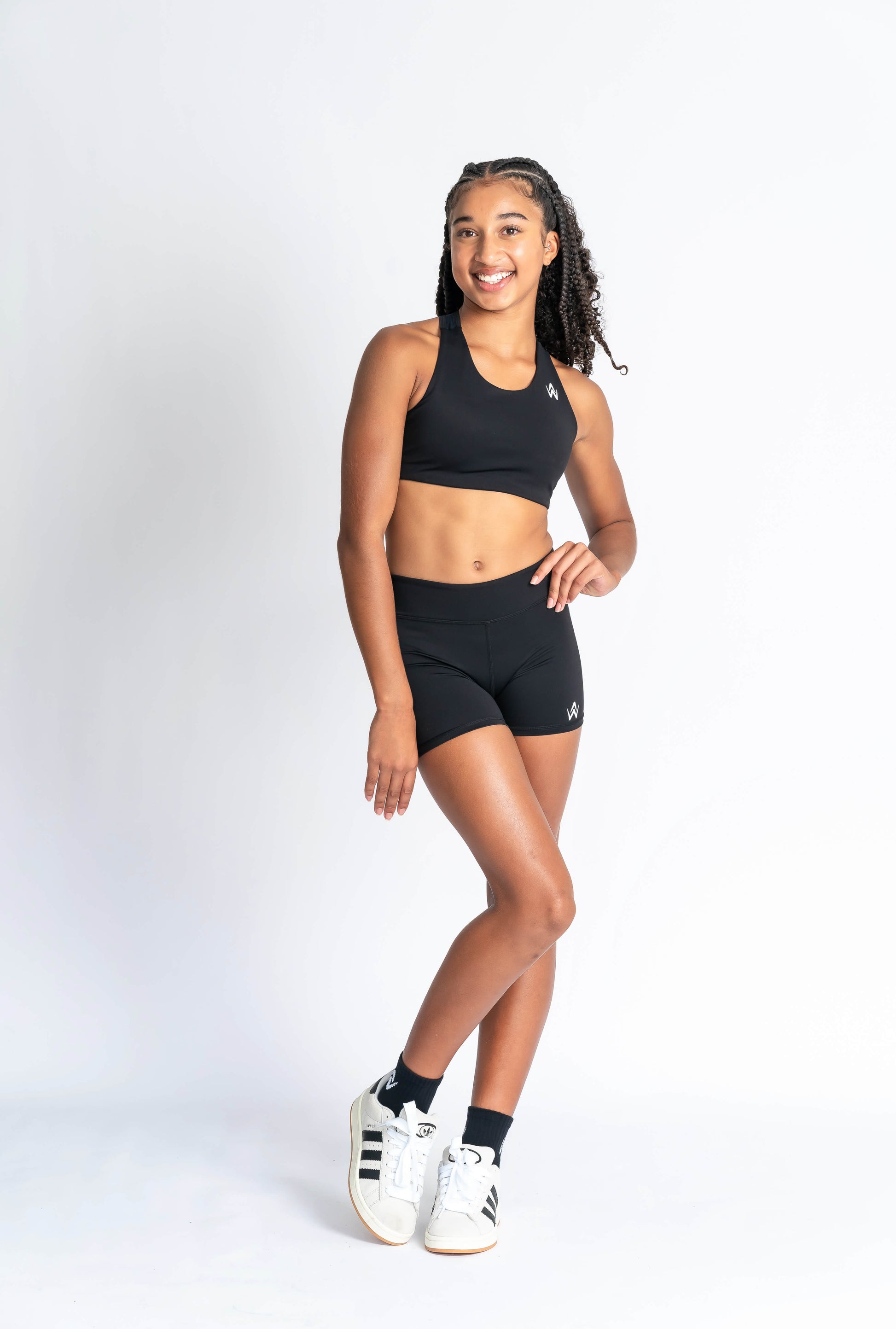 Black sports bra and black shorts with white logo branding