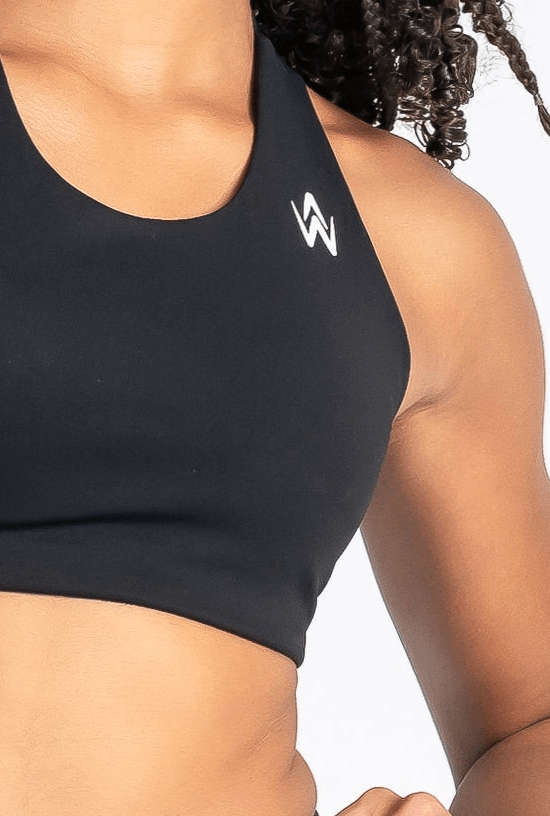 Black sports bra with a logo on a person against a neutral background