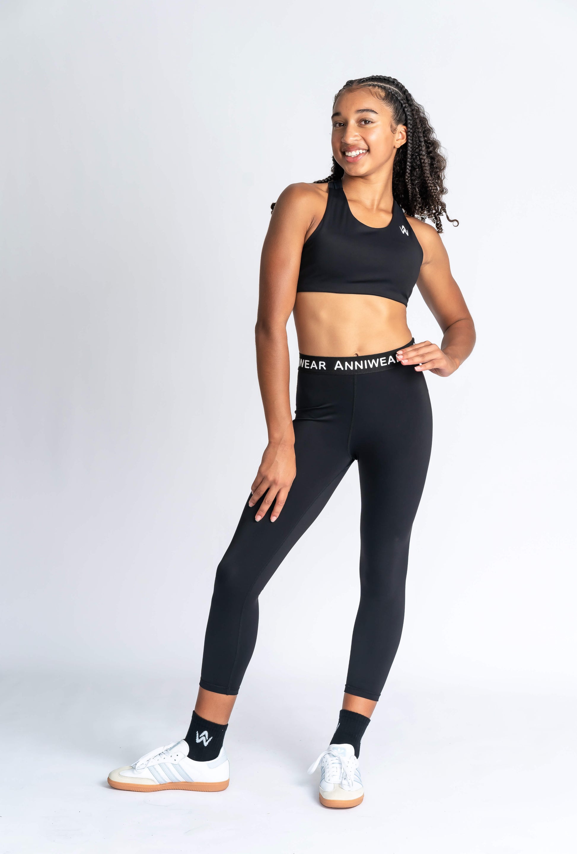 Person wearing black leggings with a visible brand logo on a white background