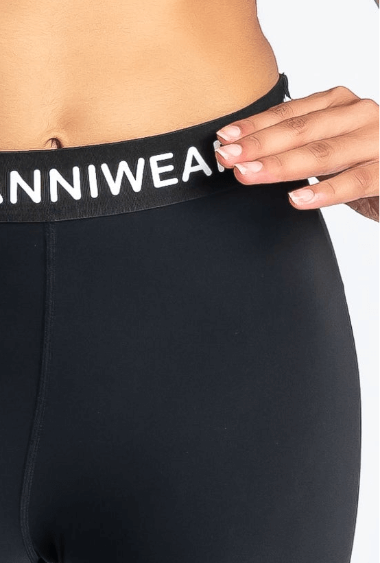 Black activewear leggings with 'ANNIWEAR' waistband on a white background