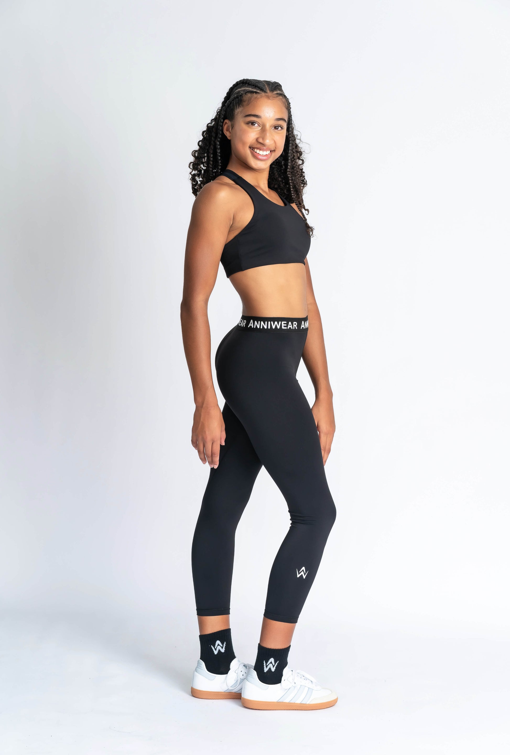 Person wearing black leggings with a visible brand logo on a white background