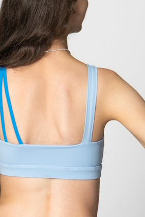 Light blue sports bra worn by a person on a plain background