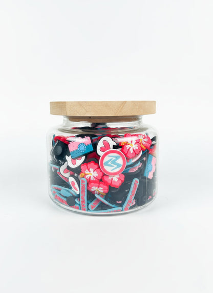 Jar filled with colorful shoe charms on a white background