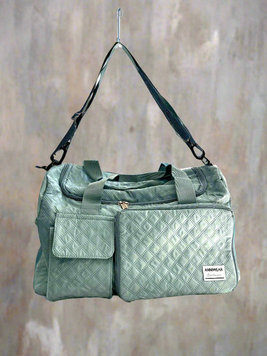 Green quilted duffel bag with a visible brand label on a textured beige background