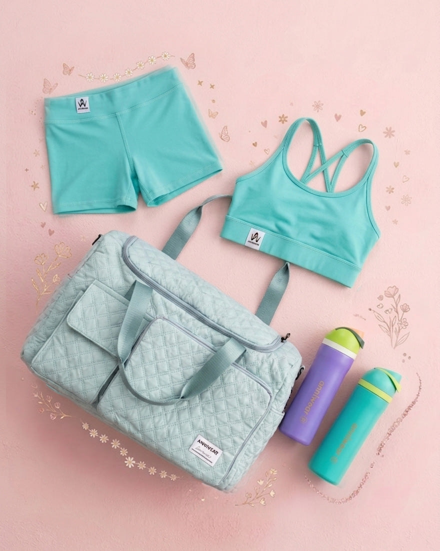 Teal sports bra and shorts set with a matching bag and water bottle on a pink background