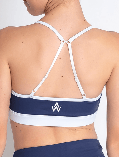 Navy and white sports bra with a logo on a plain background