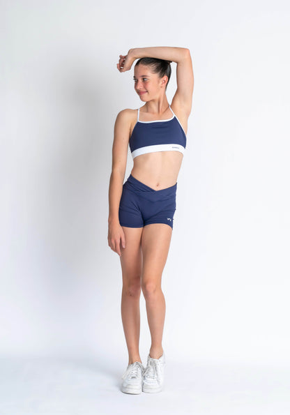 Navy and white sports bra and Navy shorts with a logo on a plain background