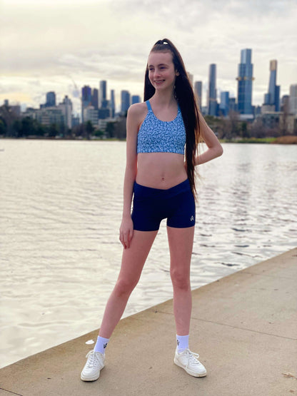 Blue floral sports bra and navy high waisted shorts on a person