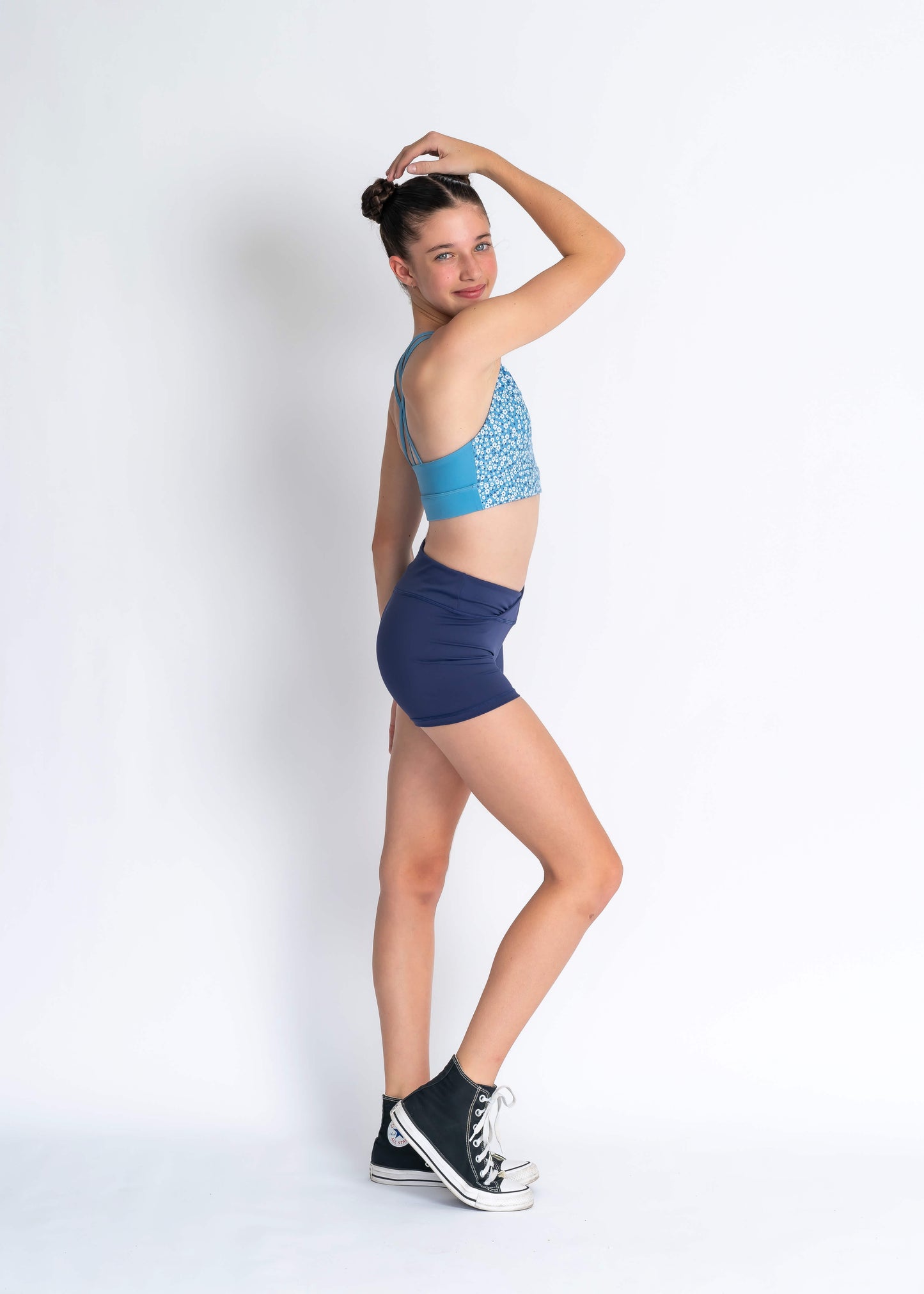 Blue floral sports bra and navy high waisted shorts on a person