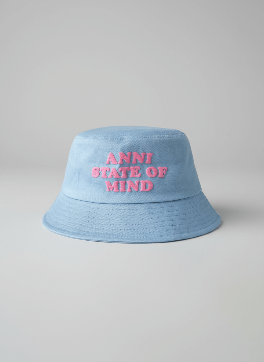 Light blue bucket hat with 'ANNI STATE OF MIND' text on a gray background
