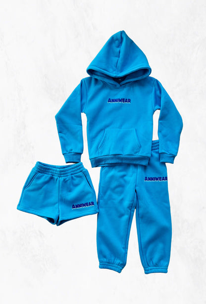 Blue tracksuit and shorts with 'ANNIWEAR' branding on white background