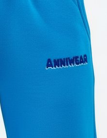Blue trackpants with 'ANNIWEAR' branding on a white background