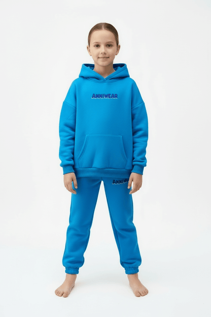 Child wearing a blue hoodie and pants with 'ANNIWEAR' branding on a white background