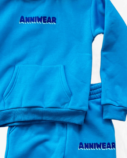 Blue tracksuit with 'ANNIWEAR' branding on a white background