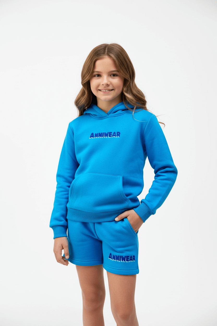 Child wearing a blue hoodie and shorts set with 'ANNIWEAR' branding on a white background