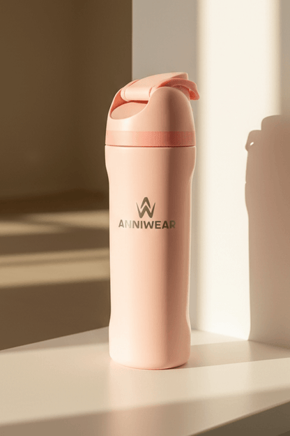 Pink water bottle with 'ANNIWEAR' branding on a light surface.