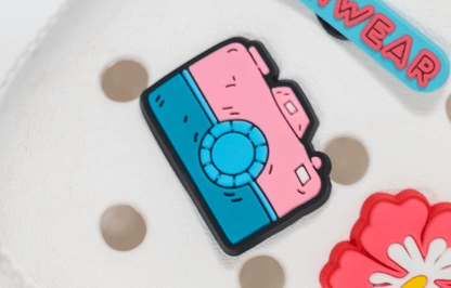 Colorful camera shaped shoe charm  on a white background.